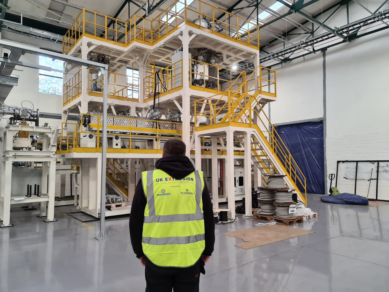 image of uk extrusion engineer with PET sheet extrusion packaging line in background